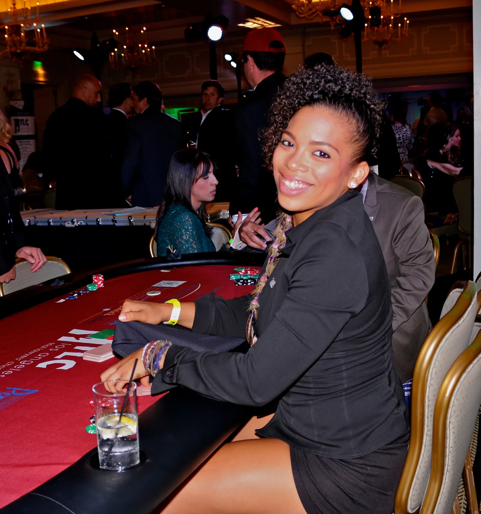 Smiling guest at a blackjack table during a charity casino fundraiser in a Los Angeles ballroom